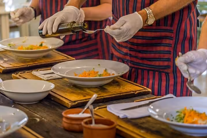 Culinary workshop in Athens with chefs preparing traditional Greek dishes using fresh ingredients.
