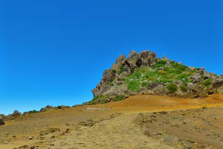 Scenic rocky landscape under clear blue skies on the Curral das Freiras & Peaks 4WD Tour, showcasing rugged Madeira terrain.