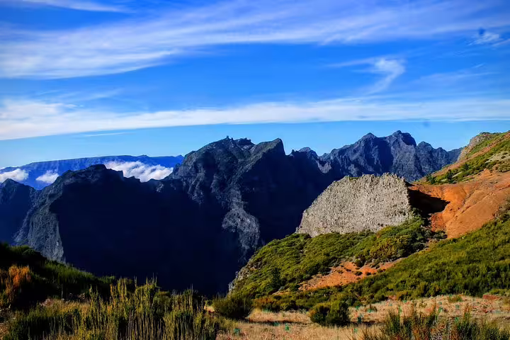 Scenic view from Curral das Freiras showcasing rugged peaks and lush valleys on a Madeira 4WD adventure tour under a clear blue sky.