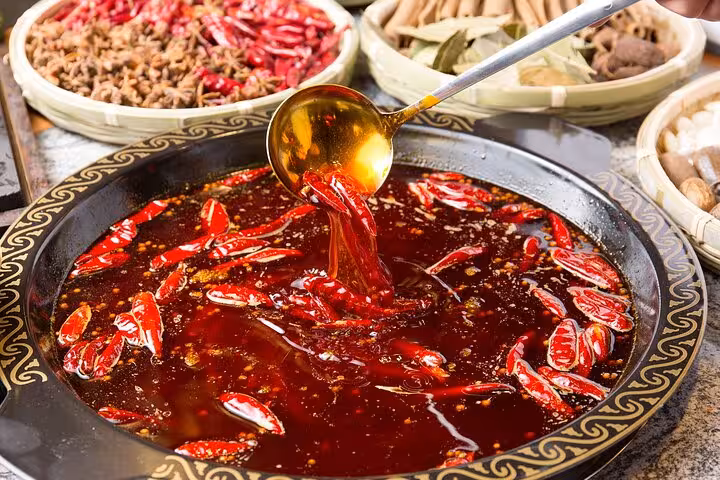 Experience authentic Chengdu hotpot with vibrant spices on a private night tour including dinner.