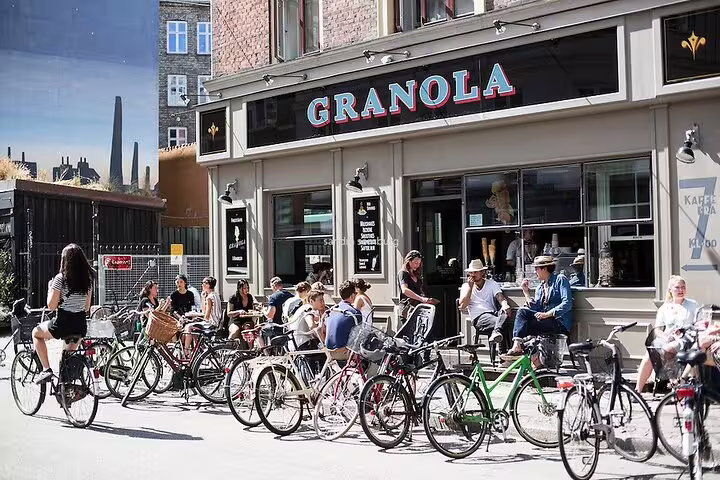 Cyclists enjoy a sunny day outside Granola café in Vesterbro, Copenhagen, a highlight of the alternative private tour.
