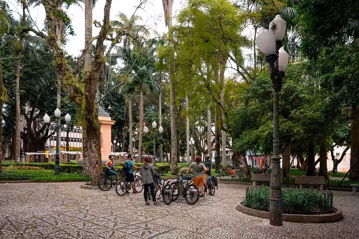 Group of cyclists exploring a lush park in Florianopolis during a bike tour focused on photography and local history.