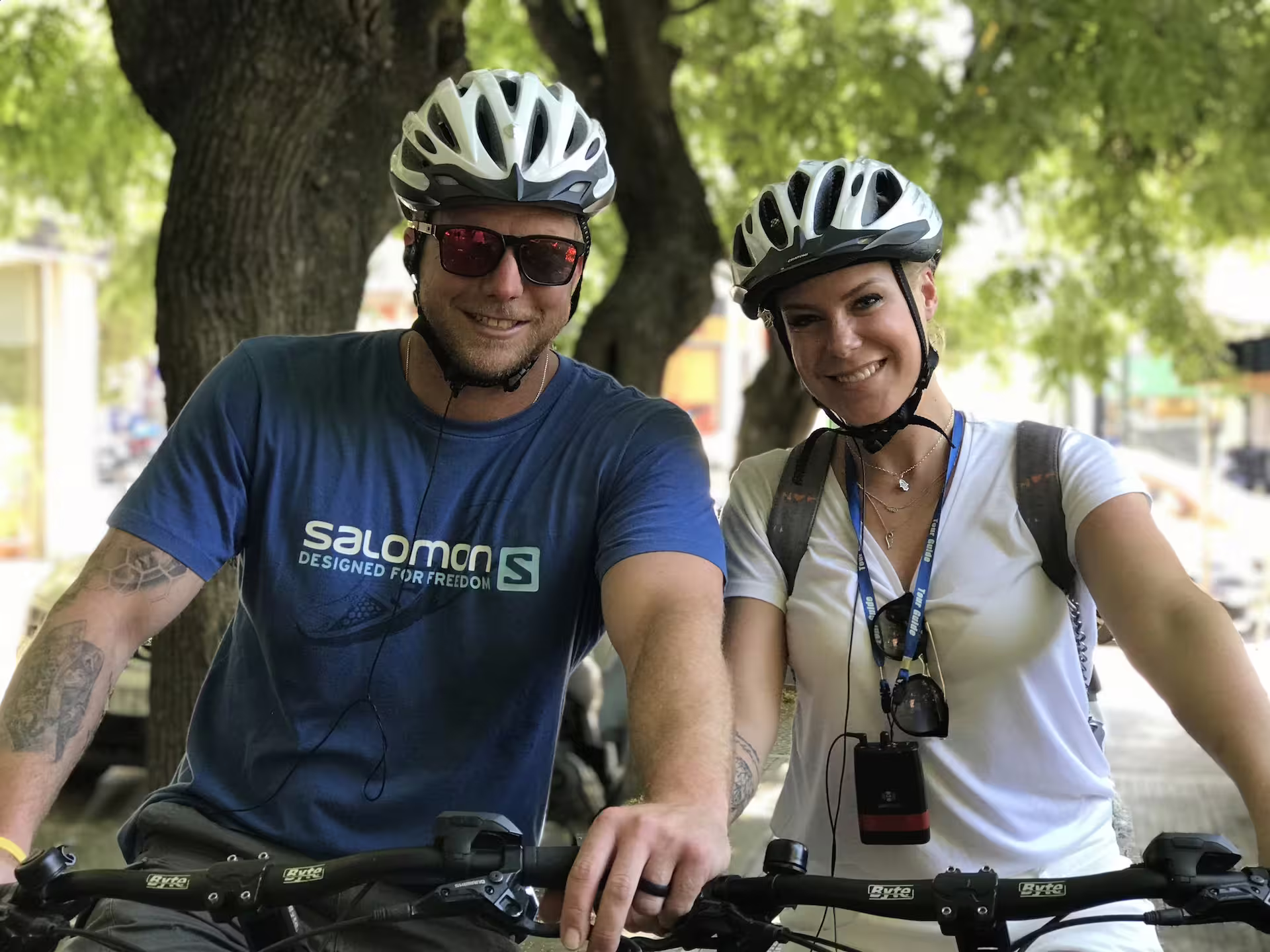Two cyclists enjoy a scenic ride through lush greenery in Athens, perfect for exploring the city's classic attractions.