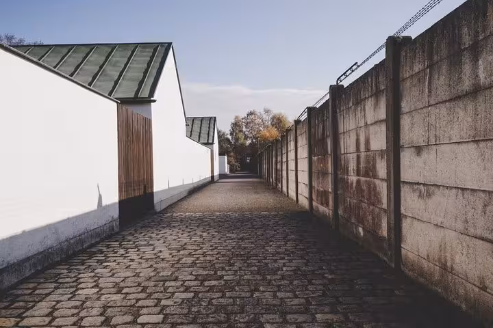 Cobblestone path and camp wall at Dachau Memorial Site, visited on a Dachau and Munich car tour from Munich