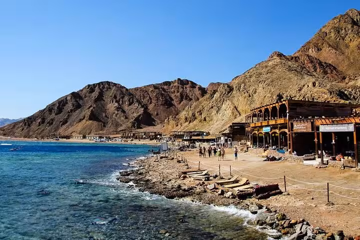 Dahab coastline by the Red Sea with beach camps and mountains, part of Jeep Safari Canyon Salama trip