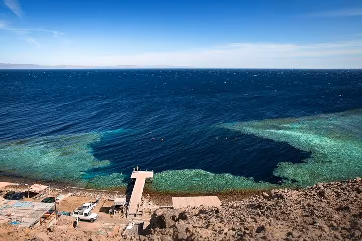 Red Sea snorkeling spot in Dahab with jetty and coral reef, part of Jeep Safari Canyon Salama tour