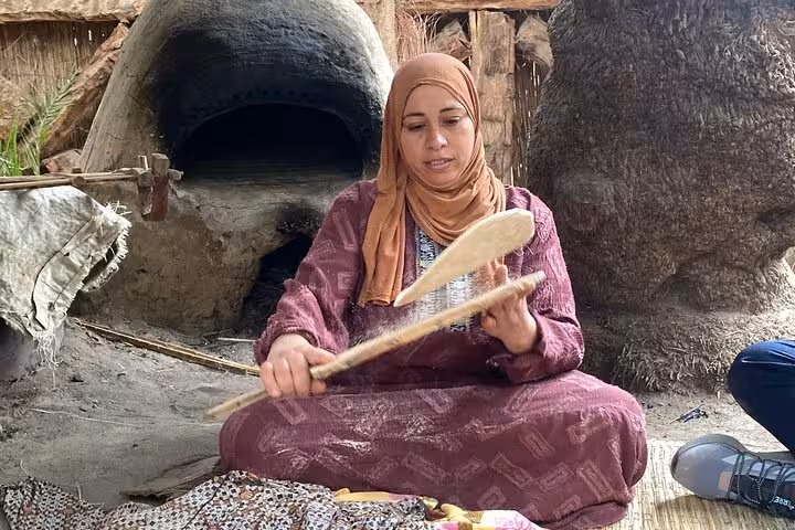 Local woman baking baladi bread in clay oven during Dahshur countryside farmer day tour with locals