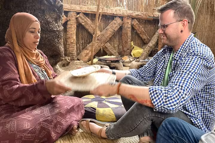 Tour guest learning to make baladi bread with a local woman on a Dahshur countryside farmer day tour
