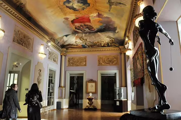 Intricate ceiling artwork and statue inside Dalí Museum, capturing surrealist art in Costa Brava.
