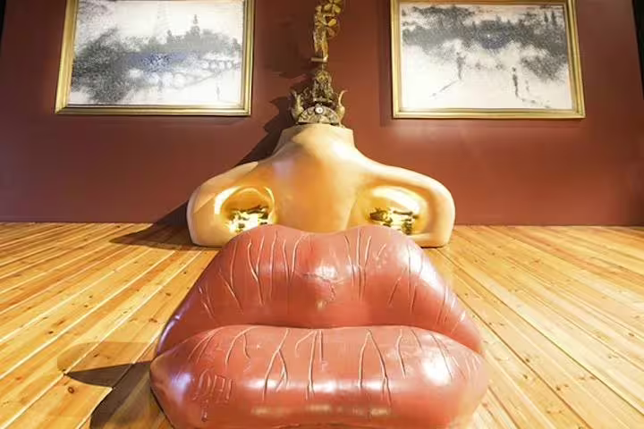 Unique Dalí installation featuring a surreal lips-shaped sofa, offering a glimpse into the artist's imaginative world.