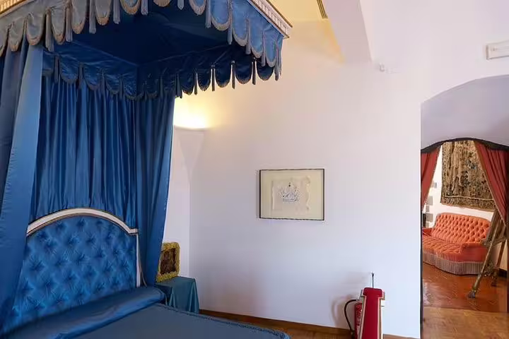 Luxurious blue canopy bed in Dalí Museum room, showcasing elegant interior design and artistic ambiance.