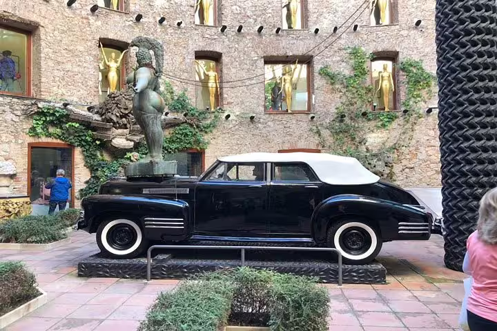 Vintage car display at Dalí Museum courtyard, illustrating creative art installations in Costa Brava.