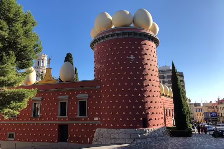 Iconic red tower adorned with giant eggs at the Dalí Theatre-Museum in Figueres, showcasing surrealist architecture.