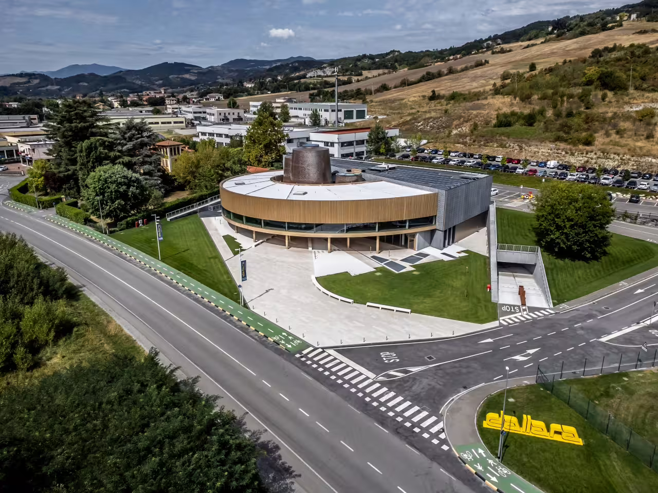 Aerial view of Dallara Academy in Parma, showcasing modern architecture amid scenic Italian countryside.