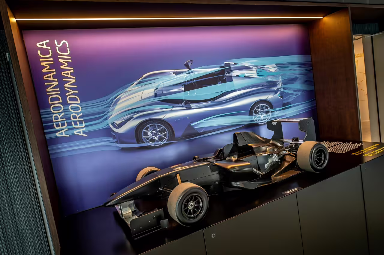 Experience cutting-edge aerodynamics with a sleek race car model at Dallara Academy's motorsport exhibition.
