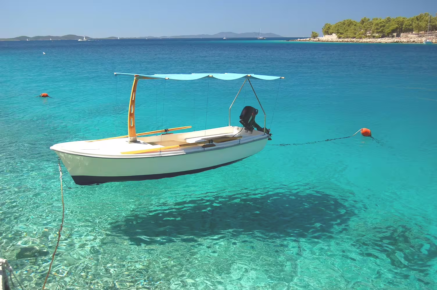 Small motorboat on crystal-clear Adriatic water near Dalmatian islands, perfect stop on a Croatia self-drive tour