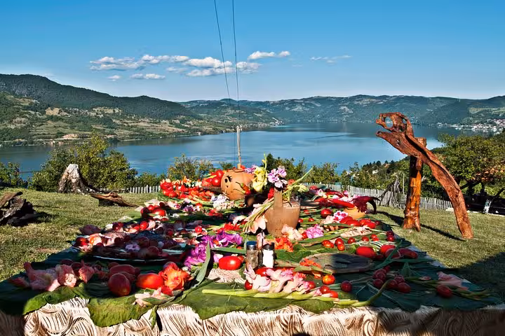 Picturesque outdoor dining setup overlooking the Danube River, featuring vibrant local produce and flowers.
