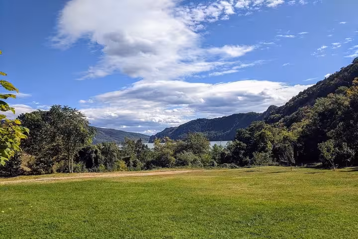 Scenic view of lush greenery and distant hills near the Danube River on a clear day, ideal for a day trip from Belgrade.