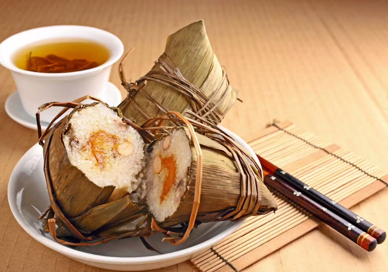 Traditional zongzi rice dumplings with tea on a bamboo mat, highlighting Datong's culinary delights on a private tour.