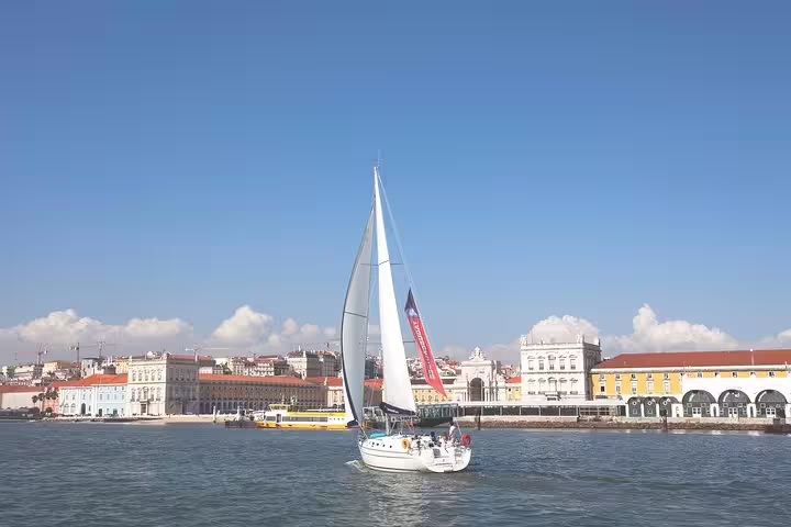 Day sailing tour on the Tagus River with a view of Lisbon's iconic waterfront and charming city buildings.