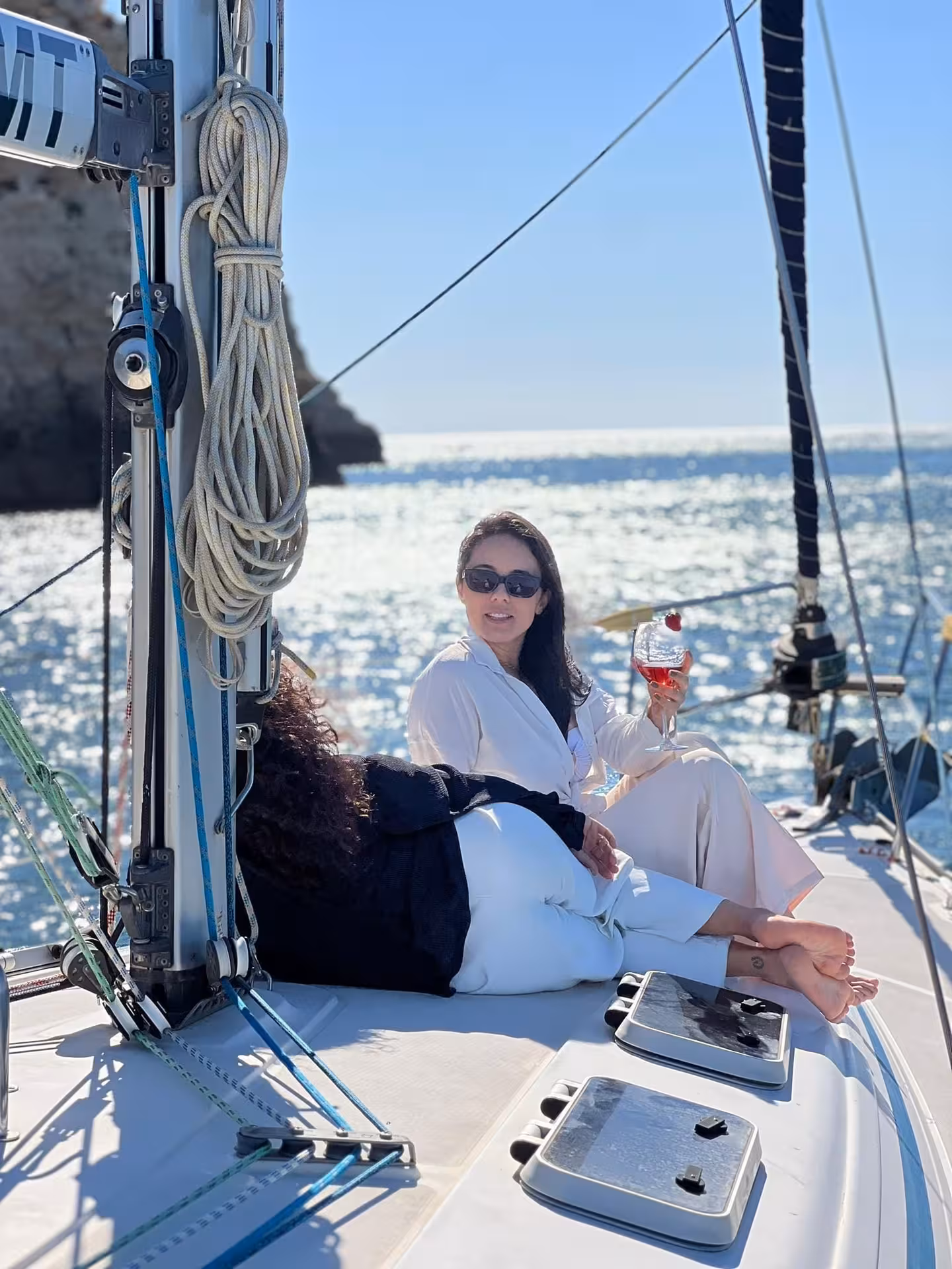 Relaxing on deck with a drink during daytime sailing tour near Lagos and Praia da Luz on Portugal’s Algarve coast