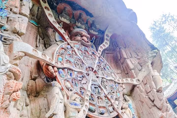 Close-up of Wheel of Life carving at Dazu Rock Carvings, Chongqing, featuring detailed ancient Buddhist art.