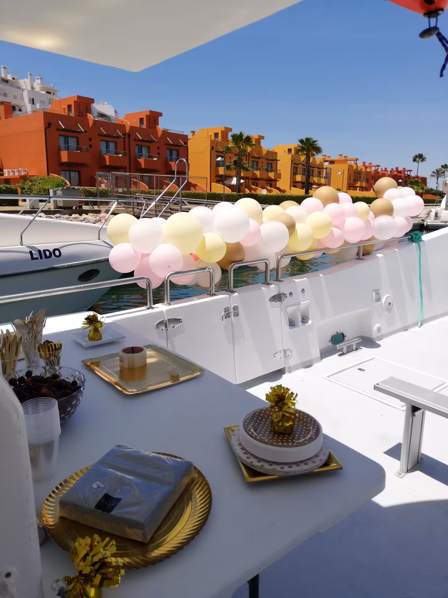 Decorated catamaran with balloons, snacks and cake in marina, ideal base for luxury private kayak tour and boat party