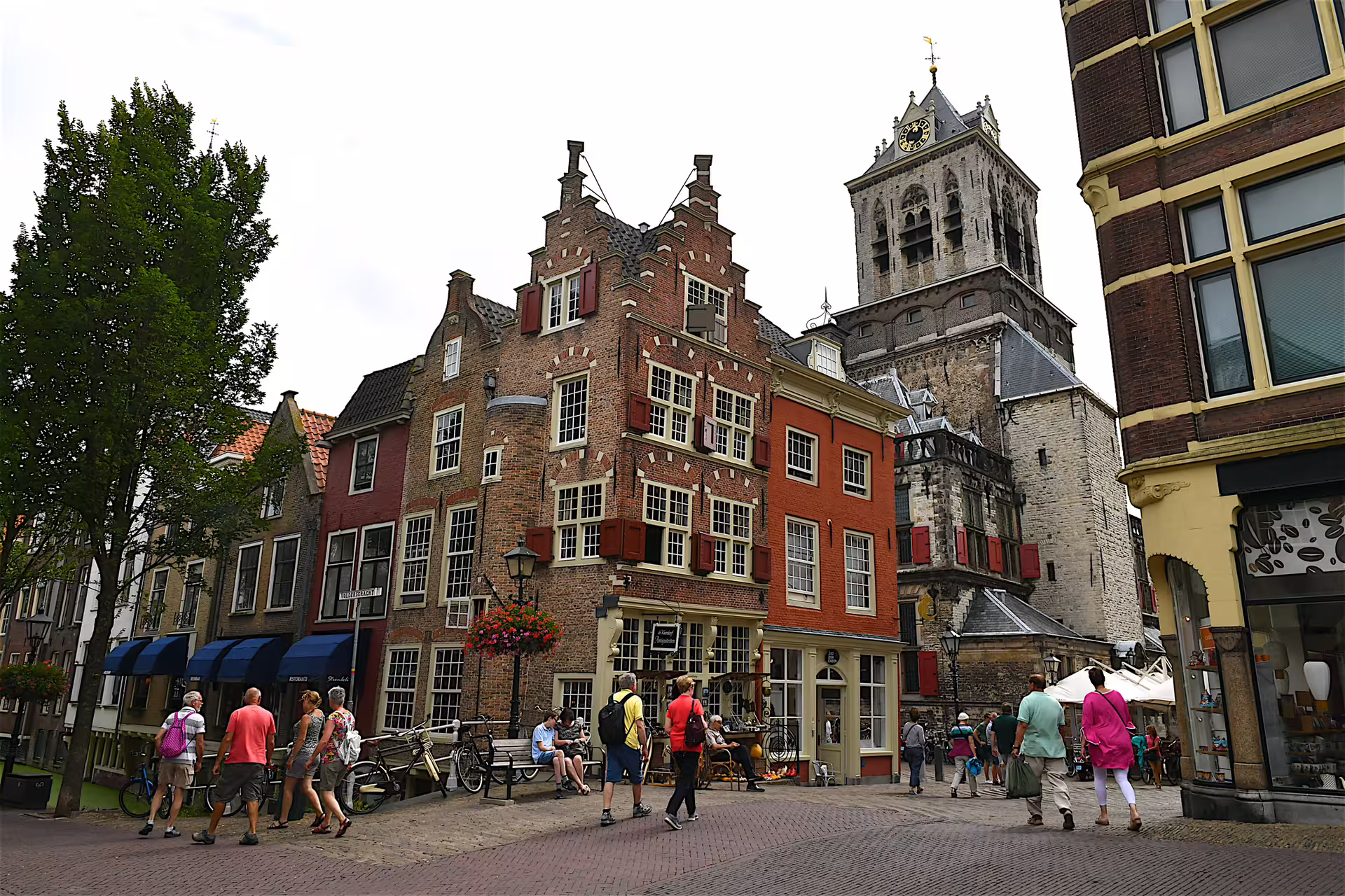 Tourists by Delft’s old town gabled buildings and clock tower, highlights on 1-day walking tour audioguide
