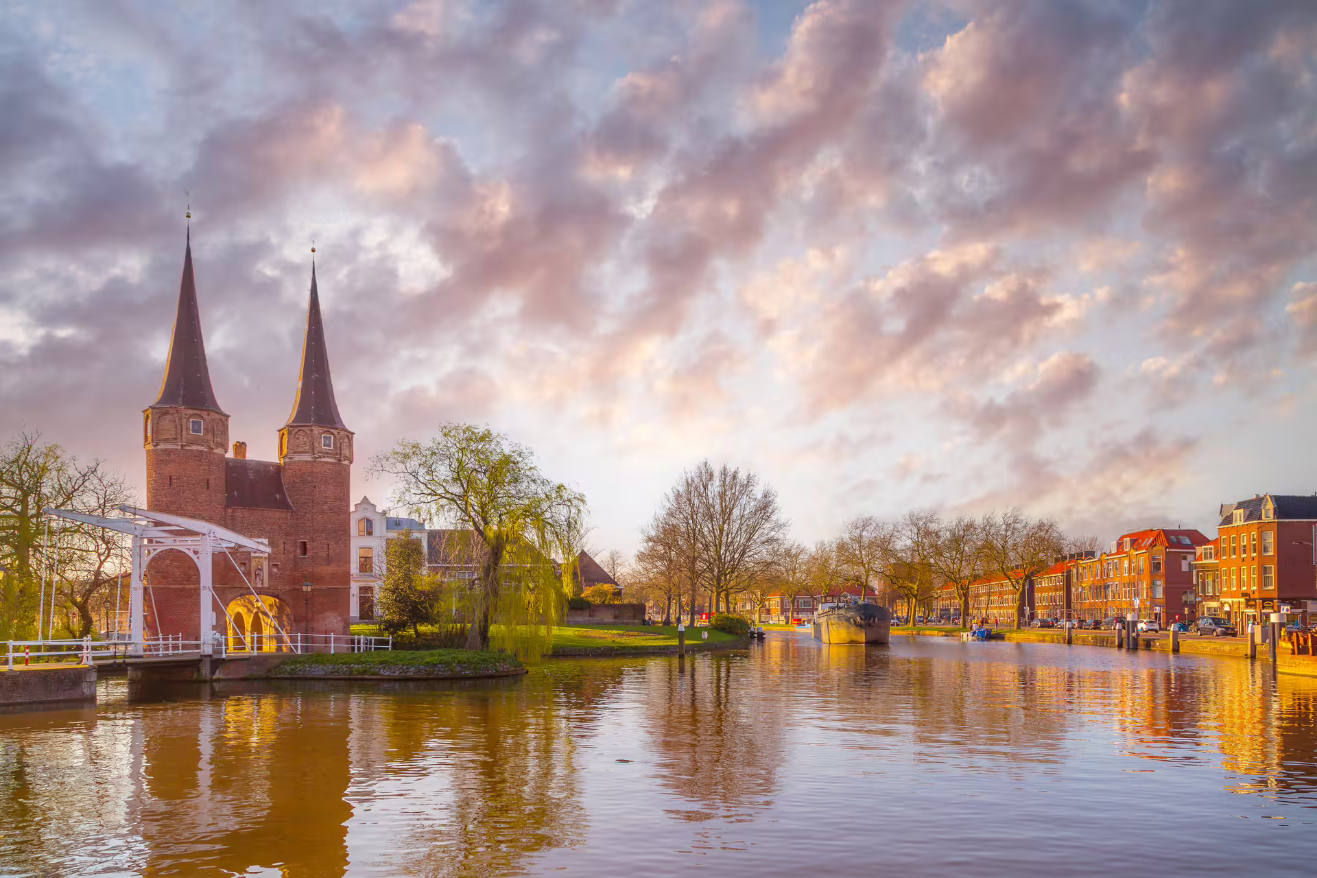 Golden hour view of Delft Oostpoort and canals, highlight of Delft in 1 day walking tour audioguide