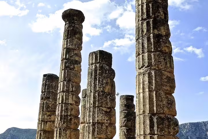 Ancient stone columns of Delphi, Greece under a bright blue sky on a private tour from Athens.