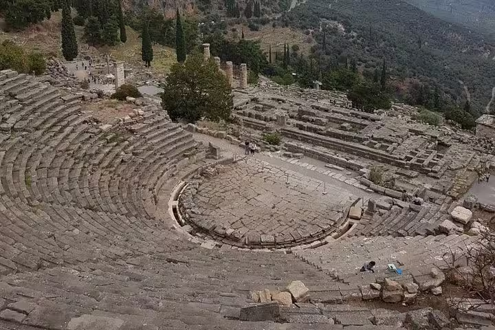 Ancient theater of Delphi with sweeping stone seats, visited on a Delphi guided small group day tour from Athens