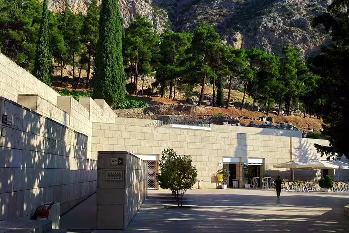 Modern entrance to the Delphi Archaeological Museum surrounded by lush greenery, ideal for Athens to Delphi day trips.