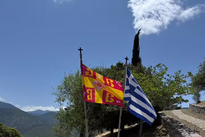Greek flag and monastery banner in Delphi countryside, scenic stop on full-day private tour from Athens