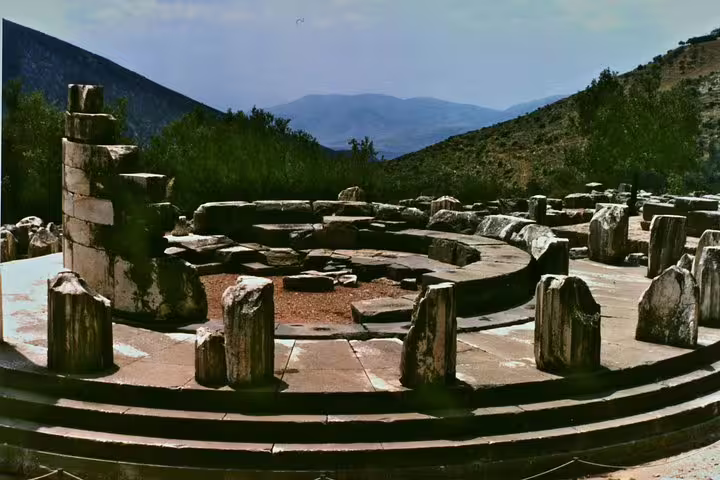 Circular stone ruins at Delphi sanctuary, key stop on a guided small group day tour from Athens