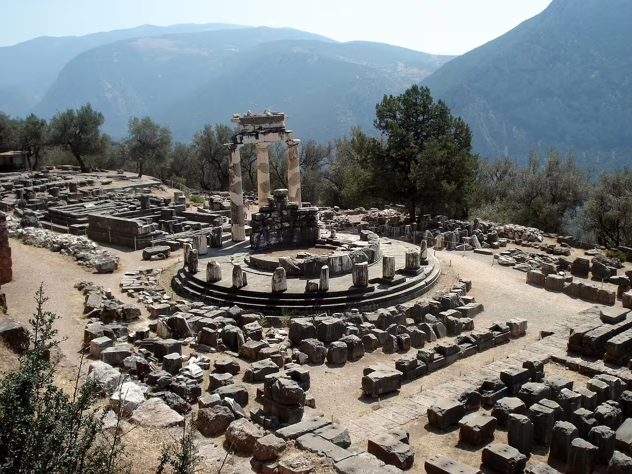 Delphi Tholos of Athena Pronaia ruins with mountain views, part of a 2-day private tour from Athens