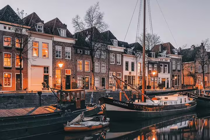 Den Bosch canal at dusk with historic houses and boats, perfect for an e-scavenger hunt city walk tour