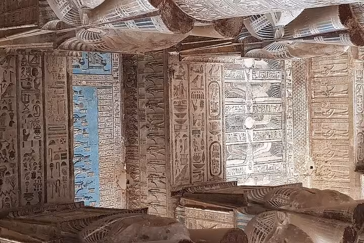Intricate hieroglyphics and blue ceiling art inside Dendera Temple during a half-day tour from Luxor.