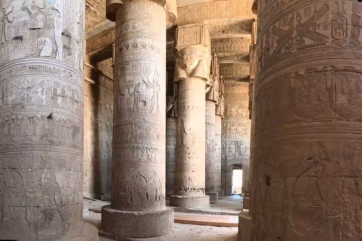 Majestic stone columns with hieroglyphics in the hypostyle hall of Dendera Temple, part of a Luxor half-day tour.