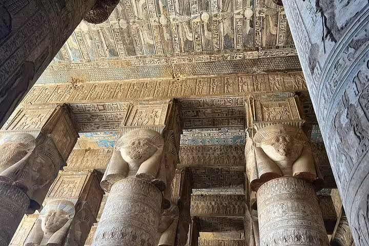 Majestic columns with detailed carvings and hieroglyphics in the Hypostyle Hall of Dendera Temple near Luxor.