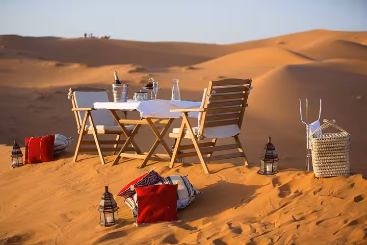 Experience a luxurious desert dining setup on the dunes during the 3 Days Desert Tour from Marrakech to Fes.
