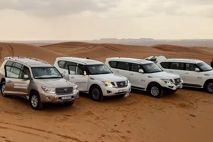 4x4 SUVs lined up for Ras Al Khaimah desert safari dune bashing, leading to camel ride and dinner camp
