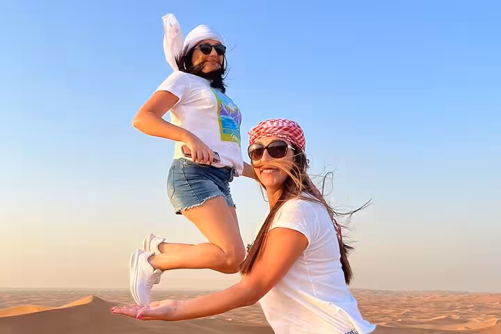 Couple enjoying Ras Al Khaimah desert safari sunset in UAE dunes before camel ride and BBQ dinner