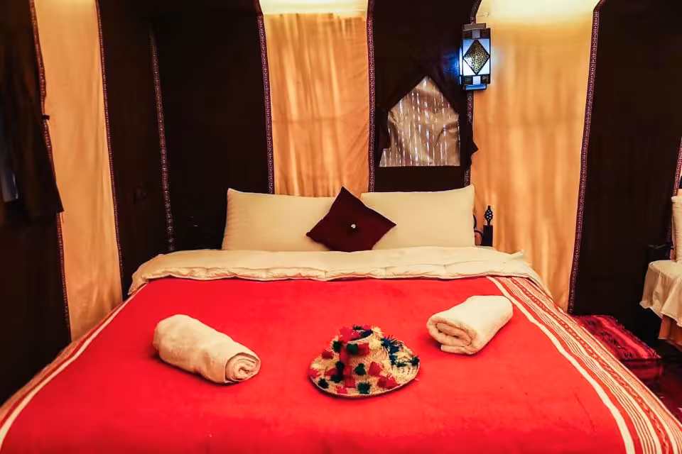 Cozy desert tent with a plush bed and traditional decor on the Fes to Marrakech tour via Merzouga.