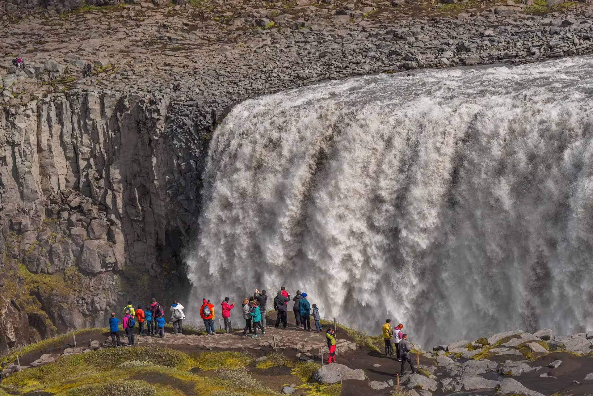 Visitors admire the powerful Dettifoss waterfall, a highlight of an 8-day Iceland small group travel experience.
