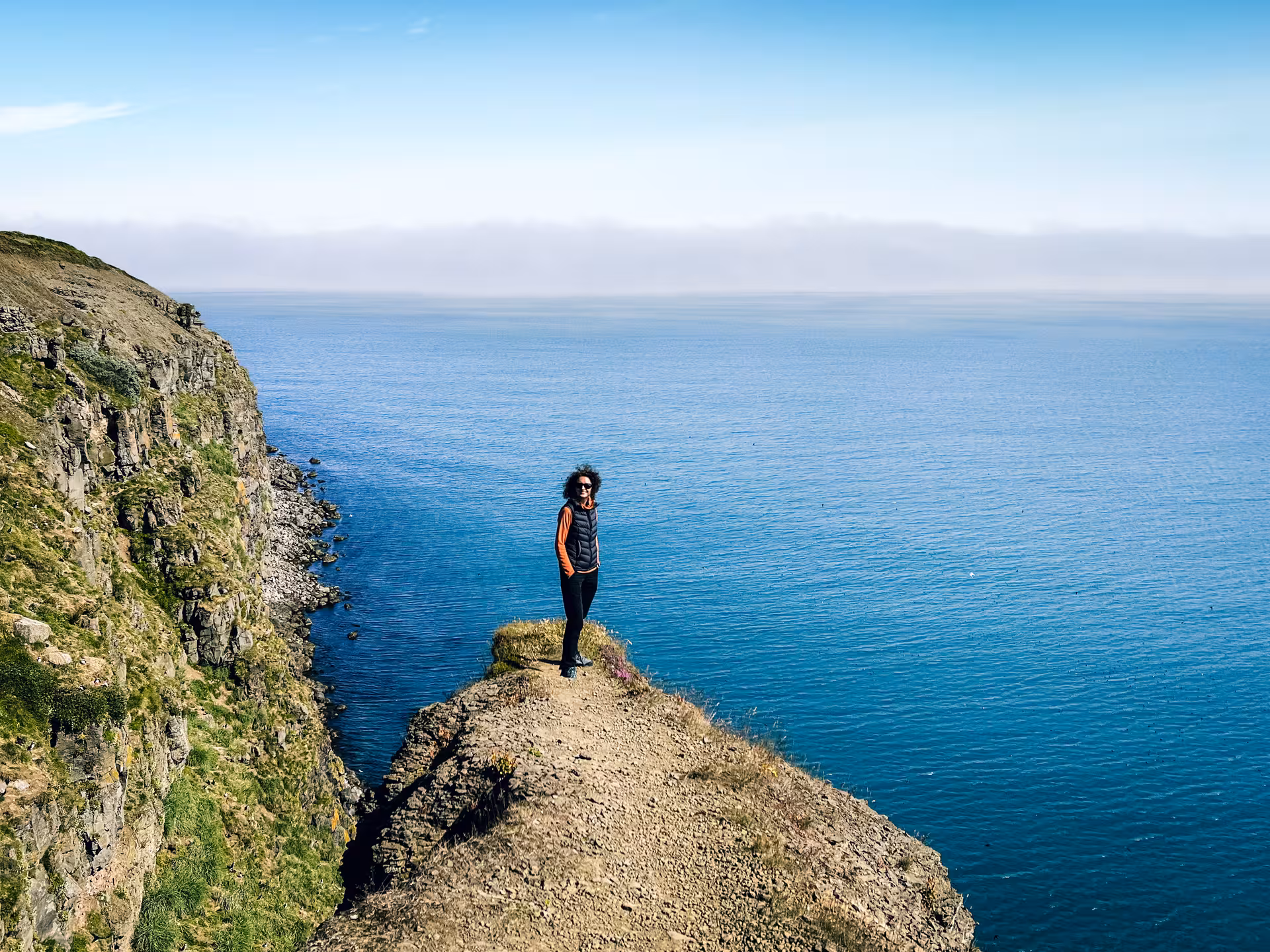 Traveler on dramatic sea cliff viewpoint, private Diamond Circle tour in North Iceland with ocean vistas