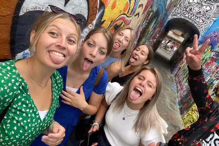 Group of friends posing by colorful street art on the Dijon e-scavenger hunt, explore at your own pace