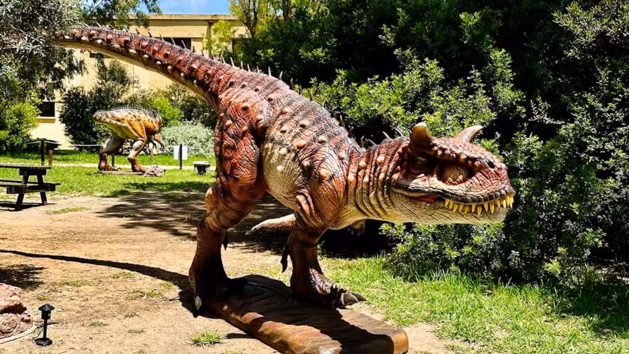Lifelike dinosaur sculptures amidst greenery in Porto Conte Park, Alghero, perfect for family exploration.