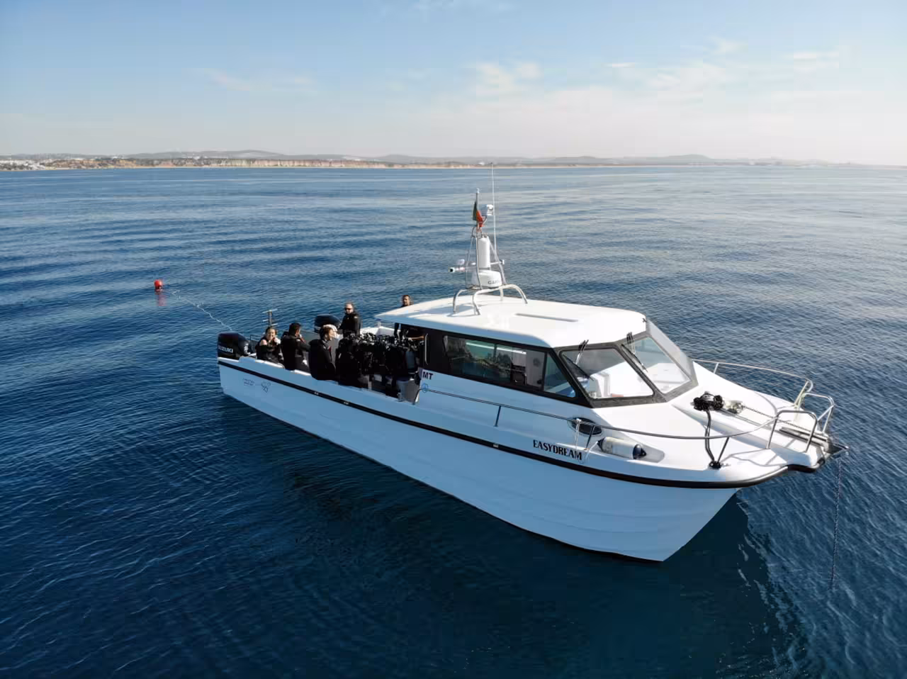 Dive boat on calm sea with scuba gear and guests heading to a beginner try dive diving baptism session