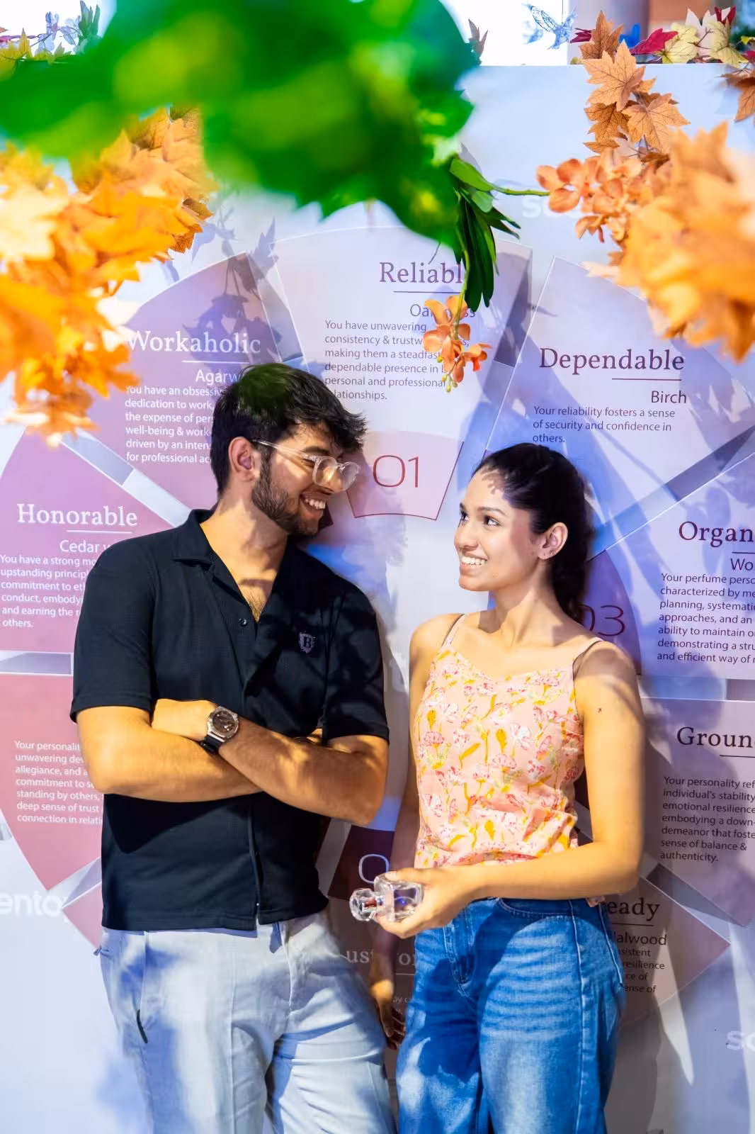 Smiling couple enjoying DIY perfume-making experience at Sentosa, Singapore, surrounded by vibrant personality boards.