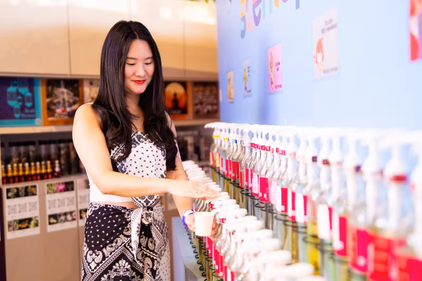 Woman creating custom fragrance at DIY perfume workshop in Sentosa, Singapore, highlighting unique perfume-making experience.
